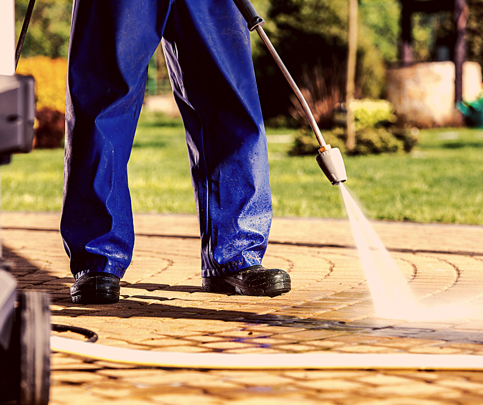 MAN PRESSURE WASHING A SIDEWALK