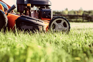 orange push mower mowing grass