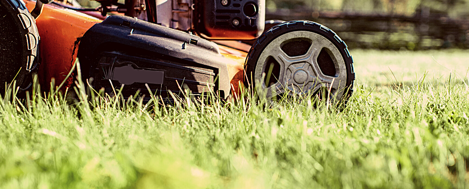 orange push mower mowing grass